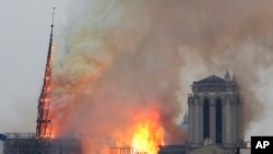 FILE - Flames rise from Notre Dame cathedral as it burns in Paris, Apr. 15, 2019.