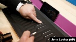 People try out the Roli Seaboard Rise at CES Unveiled, a media preview event in Las Vegas. The instruments connects to a mobile device or computer to allow you to create music.