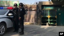 2017年11月2日，在新疆库尔勒市，警察站在一个被认为用于再教育的中心附近。
