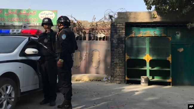 2017年11月2日，在新疆库尔勒市，警察站在一个被认为用于再教育的中心附近。