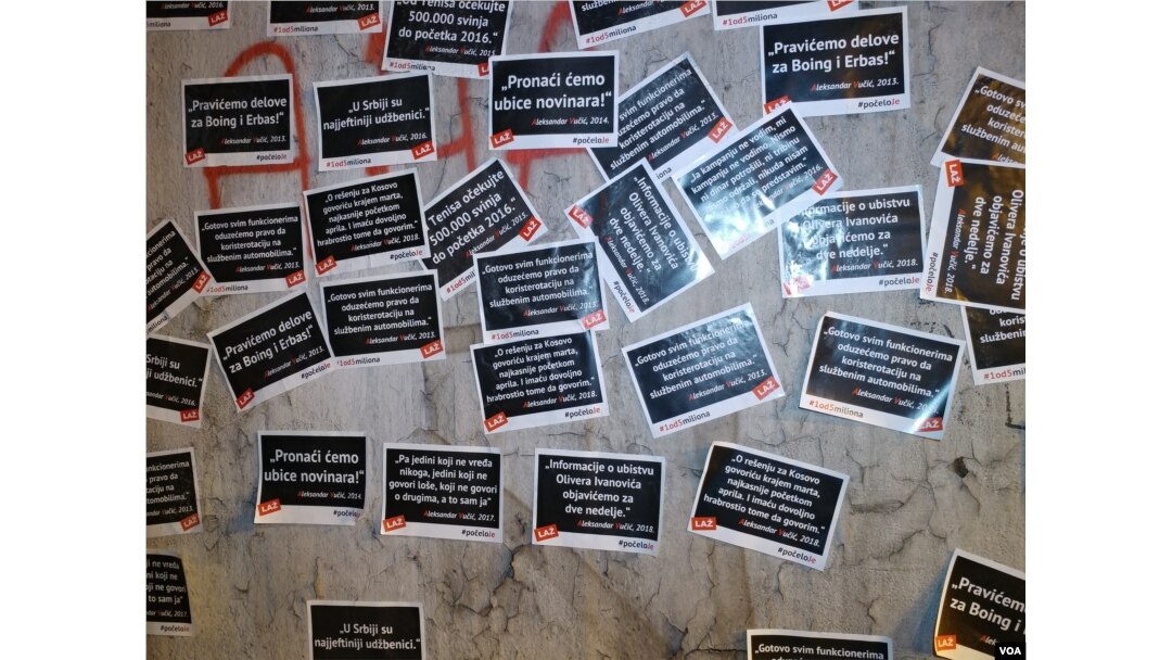 Kolona prolazi pored izlepljenih plakata sa citiranim izjavama predsednika Srbije Aleksandra Vučića i napisom "Laž" ispod svake od njih, tokom protesta "Jedan od pet miliona", u Beogradu, 23. februara 2019. (Foto: Veljko Popović, VOA)