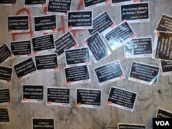 Kolona prolazi pored izlepljenih plakata sa citiranim izjavama predsednika Srbije Aleksandra Vučića i napisom "Laž" ispod svake od njih, tokom protesta "Jedan od pet miliona", u Beogradu, 23. februara 2019. (Foto: Veljko Popović, VOA)
