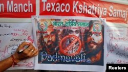 A man signs a banner during a signature campaign as part of a protest against the release of Bollywood movie "Padmavati" in Kolkata, India, Nov. 22, 2017.