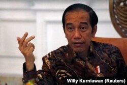 Isyarat Presiden Joko Widodo saat wawancara dengan Reuters di Istana Kepresidenan Jakarta, 13 November 2020. (Foto: REUTERS/Willy Kurniawan)