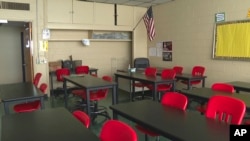 In this image made from video, an empty classroom is shown at David Ellis Academy in Detroit, Monday, Feb. 8, 2021. (AP Photo/Mike Householder File)