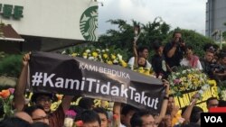 A banner reading "We Are Not Afraid" is held aloft during a vigil at the site of the Jakarta terrorist attack, Jakarta, Indonesia, Jan. 15, 2016. (S. Herman/VOA News)