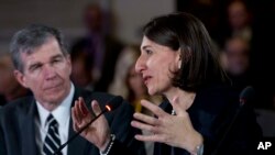 FILE - Australian NSW Premier Gladys Berejiklian speaks accompanied during the National Governor Association 2018 winter meeting, on Feb. 24, 2018, in Washington. Gov. Roy Cooper of North Carolina looks on.