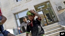 Wounded Syrians evacuate a field hospital after a second air strike in Azaz on the outskirts of Aleppo, Syria, August 15, 2012.