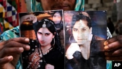 FILE - A family member shows pictures of slain model Qandeel Baloch, in Shah Sadderuddin, Pakistan, July 22, 2016.