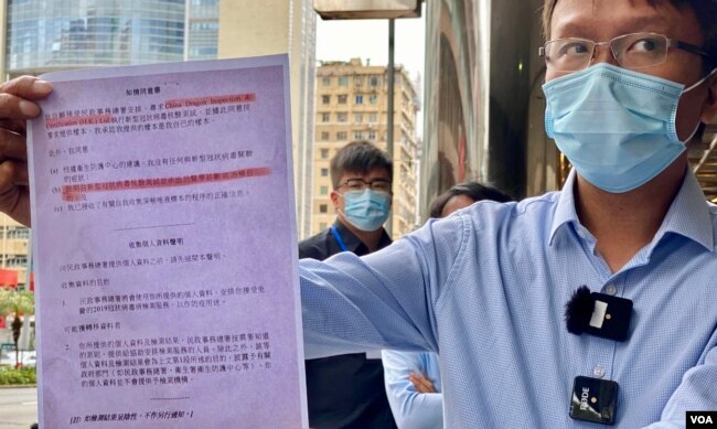 香港新同盟荃湾区议员谭凯邦展示一张香港市民接受中资公司中龙作免费病毒检测的”知情同意书”（美国之音/汤惠芸）
