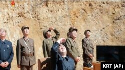 Lidè Kore di Nò a, Kim Jung Un, sant, kap gade lansman misil entèkontinantal balistik, ICBM, peyi li tap eseye a. 4 jiyè 2017, Kore di Nò. (KRT via AP Videyo)