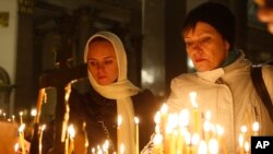 People light candles inside an Orthodox church in St.Petersburg during a day of national mourning for the plane crash victims, Russia, Nov. 1, 2015. 