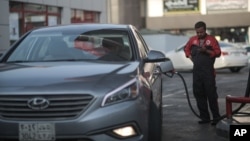 A attendant fills up a car at a gas station in Jiddah, Saudi Arabia, Sept. 15, 2015. Oil prices rose above $50 a barrel Thursday for the first time this year.