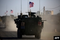 FILE - A convoy of U.S. forces armored vehicles drives near the village of Yalanli, on the western outskirts of the northern Syrian city of Manbij, March 5, 2017. Some analysts say the U.S. is inching closer to a much more explicit shift in policy in Syria - one exclusively focused on the war against the Islamic State.