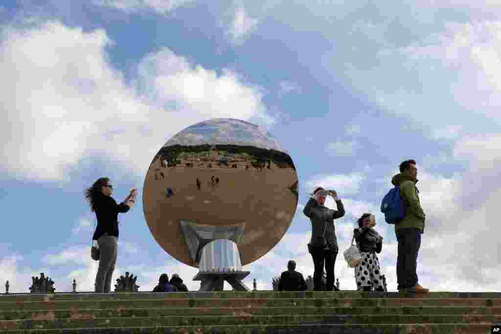 Visitors take picture of the front of &quot;Sky Mirror&quot; by British-Indian artist Anish Kapoor in the Versailles castle in Versailles, France.