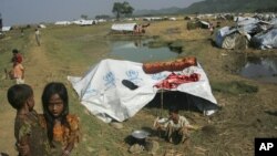 Muslim refugees stand near their tent at Sin Thet Maw relief camp in Pauk Taw township, Rakhine state, western Myanmar, November 10, 2012.