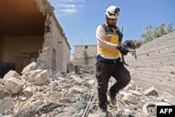 A member of the Syrian Civil Defense caries a cat amidst rubble from a building damaged during reported shelling by government and allied forces, in the town of Hbeit in the southern countryside of the rebel-held Idlib province, May 3, 2019.