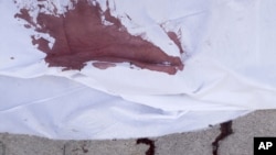 The blood of a Syrian civilian, killed by a Syrian Army sniper, is seen on the sidewalk outside Dar el-Shifa Hospital in Aleppo, September 27, 2012. 