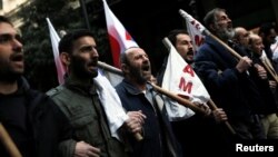 Protesters from the communist-affiliated trade union PAME shout slogans during a demonstration against changes to laws about calling strikes in Athens, Greece, Jan. 9, 2018. 