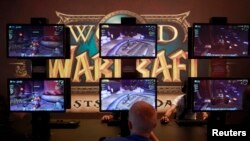 Visitors play ''World of Warcraft'' at an exhibition stand during the Gamescom 2012 fair in Cologne August 15, 2012. The Gamescom convention, Europe's largest video games trade fair, runs from August 16 to August 19. (REUTERS/Ina Fassbender)