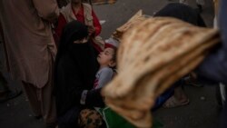 An Afghan woman begs at a market in Kabul's Old City, Afghanistan, Sept. 14, 2021. A month after the fall of Kabul, the question of how the world will get aid to citizens without enriching Afghanistan's Taliban rulers.