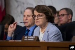 FILE - Sen. Dianne Feinstein, D-Calif., right, joined at left by Sen. Ron Wyden, D-Ore., listen as former FBI director James Comey testifies before the Senate Select Committee on Intelligence, on Capitol Hill in Washington, June 8, 2017.