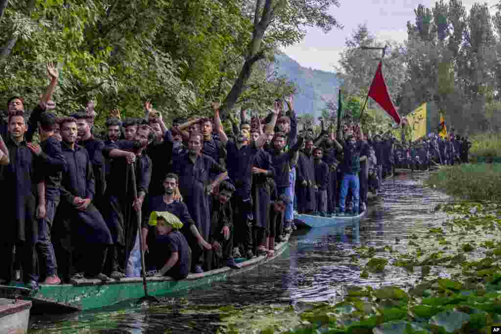 Kashmiri Shi&#39;ite Muslims participate in a Muharram procession on wooden boats in the Dal lake, outskirts of Srinagar, Indian-controlled Kashmir.