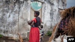 A woman holds her child at a makeshift camp for internally displaced persons (IDPs) among old abandoned buildings in Kalemie, Tanganyika province, Democratic Republic of the Congo, Sept. 18, 2017.