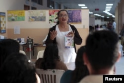 FILE - Patients participate in a Zika prevention talk as they wait to be attended to at the Women's National Hospital in San Salvador, El Salvador, Jan. 29, 2016.