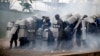 Police stand amid tear gas as they clash with supporters of opposition presidential candidate Salvador Nasralla near the institute where election ballots are stored in Tegucigalpa, Honduras, Nov. 30, 2017. Protests are growing as incumbent President Juan Orlando Hernandez emerged with a growing lead for re-election following a reported computer glitch that shut down vote counting for several hours.