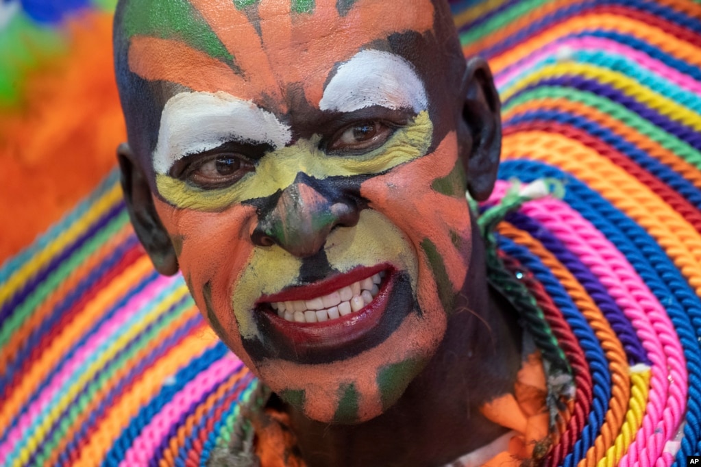 A man with a colorful painted face promotes traveling to the Dominican Republic at the ITB tourism fair in Berlin, Germany.