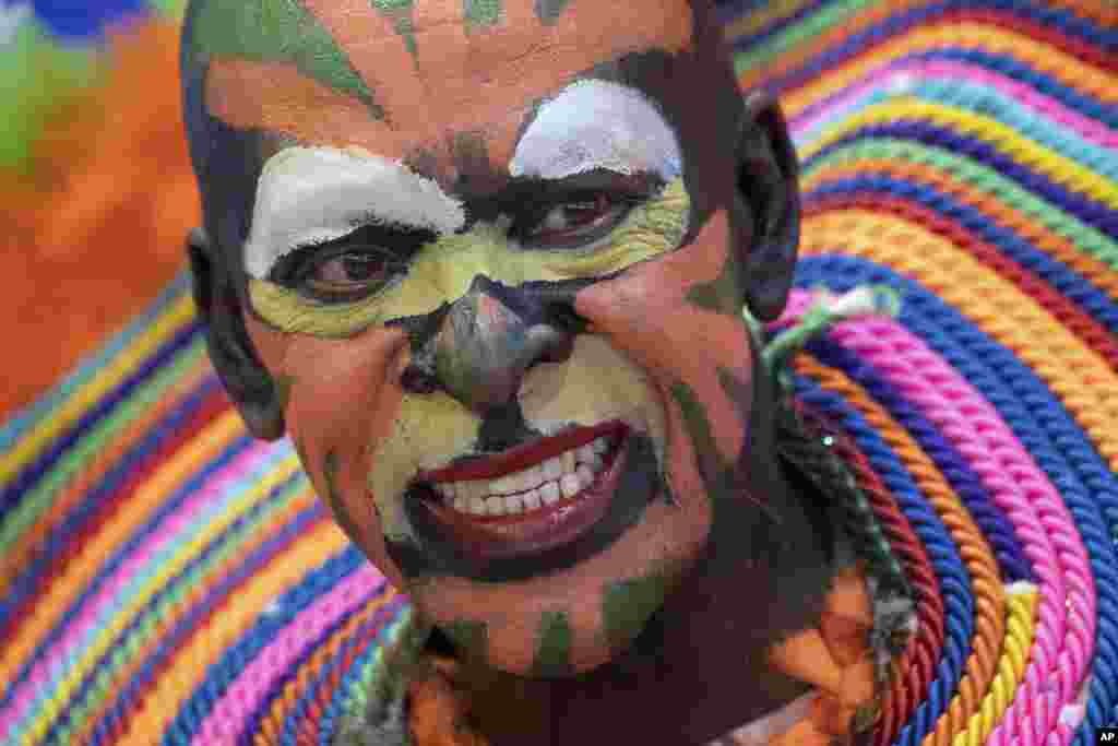 A man with a colorful painted face promotes traveling to the Dominican Republic at the ITB tourism fair in Berlin, Germany.