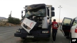 This image provided by the Syrian Arab Red Crescent shows the aftermath of an attack on a humanitarian aid convoy that came under fire shortly before dark Saturday, June 17, 2017, outside Damascus, Syria. 