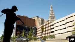 FILE - A worker cleans the sidewalk in front of the Quicken Loans Arena in Cleveland, site of this year's Republican National Convention.