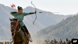 In this photo taken on September 6, 2018, a women shoots an arrow in a competition during the Third Nomad Games, in Cholpon-Ata, 250 kilometers from Bishkek, Kyrgyzstan. (AP Photo)