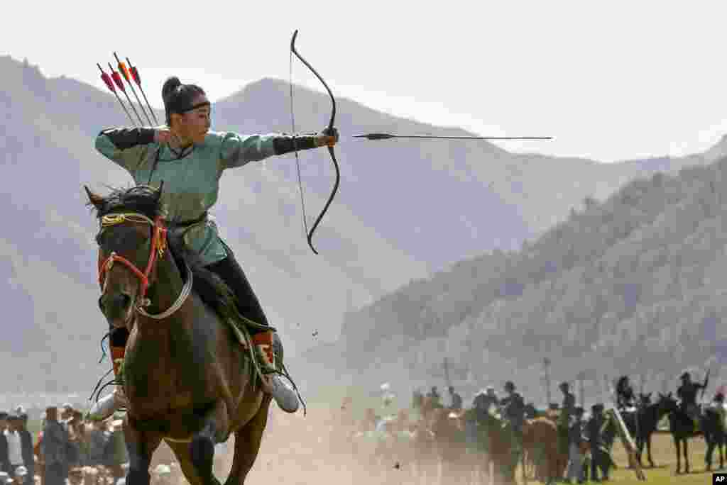 A women participates in an archery competition during the Third Nomad Games, in Cholpon-Ata, 250 kilometers (156 miles) of Bishkek, Kyrgyzstan.