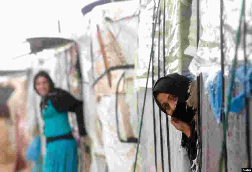 A Syrian refugee looks out of her tent in a camp in Tyre, southern Lebanon January 31, 2013. 