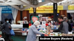 People shop at Leicester Market, amid the spread of the coronavirus disease (COVID-19), in Leicester, Britain.