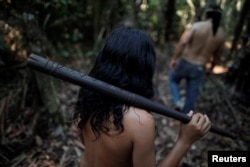 Indigenous people from the Mura tribe walk in a deforested area in nondemarcated indigenous land inside the Amazon rainforest near Humaita, Amazonas State, Brazil August 20, 2019.