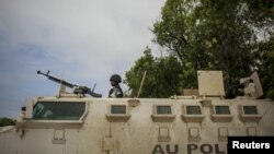 Ugandan police officer serving with the African Union Mission in Somalia's first Formed Police Unit stands at the top of an armored personnel carrier at a police station in the capital Mogadishu, August 7, 2012.