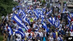 People march with Nicaraguan national flags during the commemoration of Student Day, demanding the ouster of President Daniel Ortega and the release of political prisoners, in Managua, July 23, 2018. 
