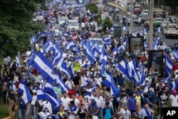 FILE - People march with Nicaraguan national flags during the commemoration of Student Day, demanding the ouster of President Daniel Ortega and the release of political prisoners, in Managua, July 23, 2018.