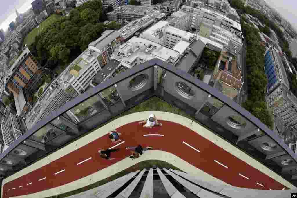 People in their running gear, run along a stretch of the new 150-meter rooftop running track, as seen from the roof terrace of the recently redeveloped 16-storey office tower of the White Collar Factory development in London. The new track is the highest one in London.