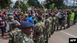 Des miltants de l'opposition au Malawi sont rassemblés dans une manifestation antigouvernementale sous la vigilance des membres des forces de sécurité du pays à Lilongwe, au Malawi, le 27 avril 2018.