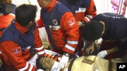 Turkish rescuers tend Ferhat Tokay, 13, after he was pulled from the rubble of a collapsed building in Ercis, Van, Turkey, October 28, 2011.