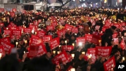 Para pengunjuk rasa membawa lilin dalam aksi protes menuntut Presiden Park Geun-hye untuk turun dari jabatannya, di Gwanghwamun, gerbang utama istana Gyeongbok, Seoul, Korea Selatan (3/12).