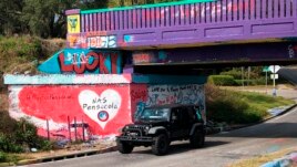 A vehicle drives by a tribute to victims of the Naval Air Station Pensacola that was freshly painted on what’s known as Graffiti Bridge in downtown Pensacola, Florida, on Saturday, December 7, 2019.