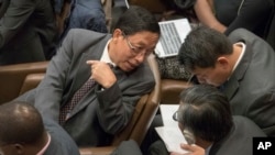 FILE - Myanmar Ambassador to the United Nations, Hau Do Suan, left, speaks to members of his delegation during a General Assembly's human rights committee meeting, Nov. 16, 2017, at United Nations headquarters.