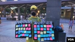 一位自稱參加了香港“反送中運動”所有大遊行的香港女學生在台北車站廣場舉起“連儂板”。（2019年7月27日，美國之音林楓拍攝）