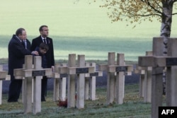 El presidente francés, Emmanuel Macron (derecha) rinde tributo junto a la tumba del teniente Robert Porchon, hermano en armas del escritor francés Maurice Genevoix muerto durante la Primera Guerra Mundial en el Cementerio Les Eparges, este de Francia, el 6 de noviembre de 2018.